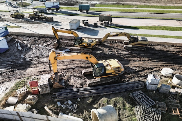 Varias excavadoras poderosas están trabajando en la vista del sitio de construcción desde arriba Fotografía de drones Movimientos de tierra con equipo pesado en el sitio de construcción