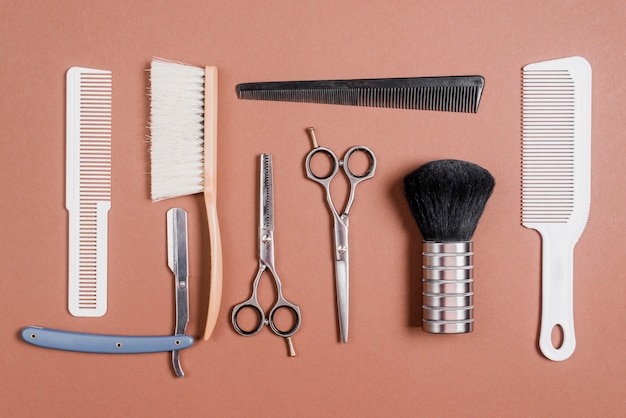 Várias ferramentas de barbeiro em pano de fundo marrom