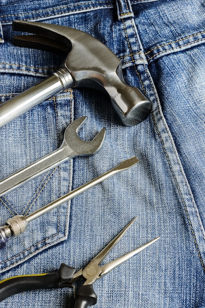 Várias ferramentas em um bolso de trabalhadores de jeans