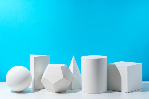 Varias formas geométricas dispuestas en una superficie contra un fondo azul brillante