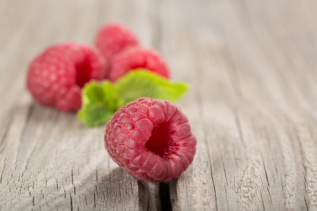 Várias frutas de framboesa no velho close-up de uma mesa de madeira