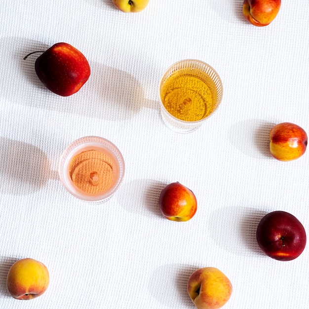 Varias frutas y dos copas de vino con largas sombras.