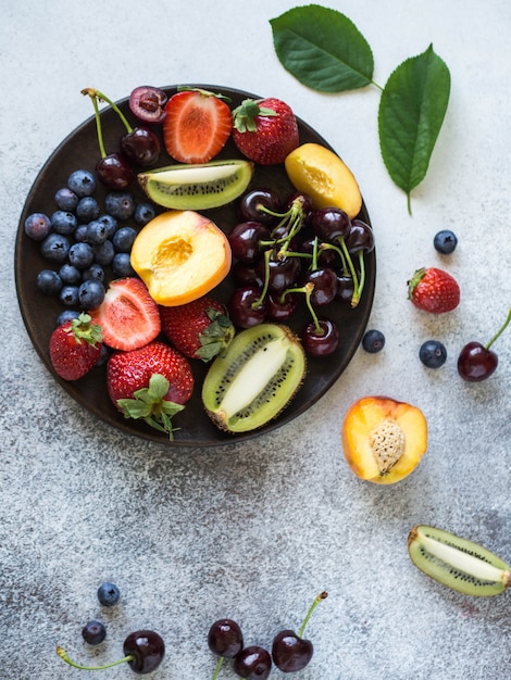 Várias frutas e bagas em uma placa de madeira