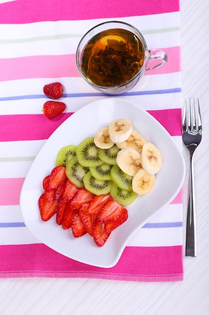 Várias frutas fatiadas no prato na mesa fechada