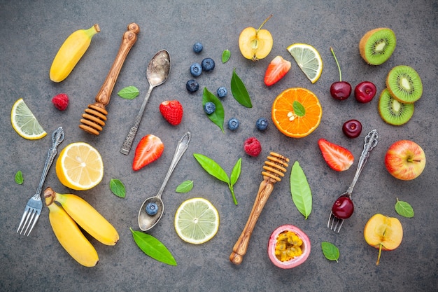 Várias frutas misturadas no fundo de pedra escuro para o projeto do menu dos doces.