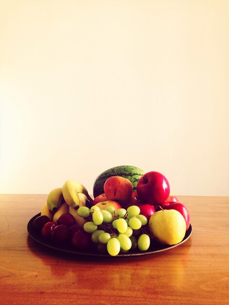 Foto várias frutas no prato na mesa