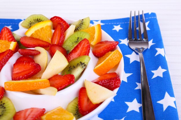 Foto varias frutas en rodajas en un plato en el primer plano de la mesa