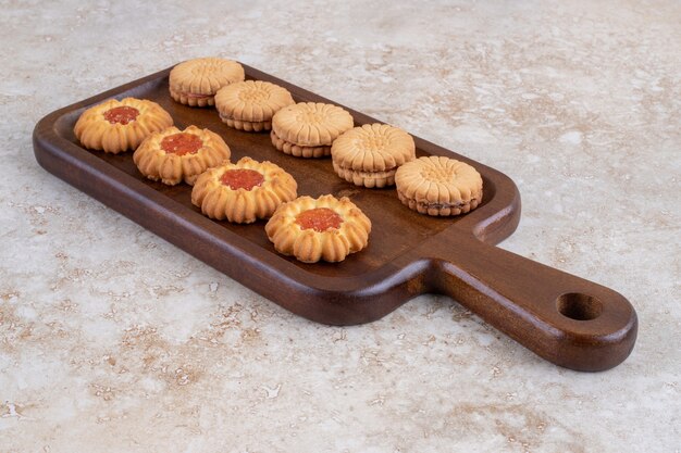 Varias galletas y cacahuetes pelados sobre una tabla, sobre el mármol.