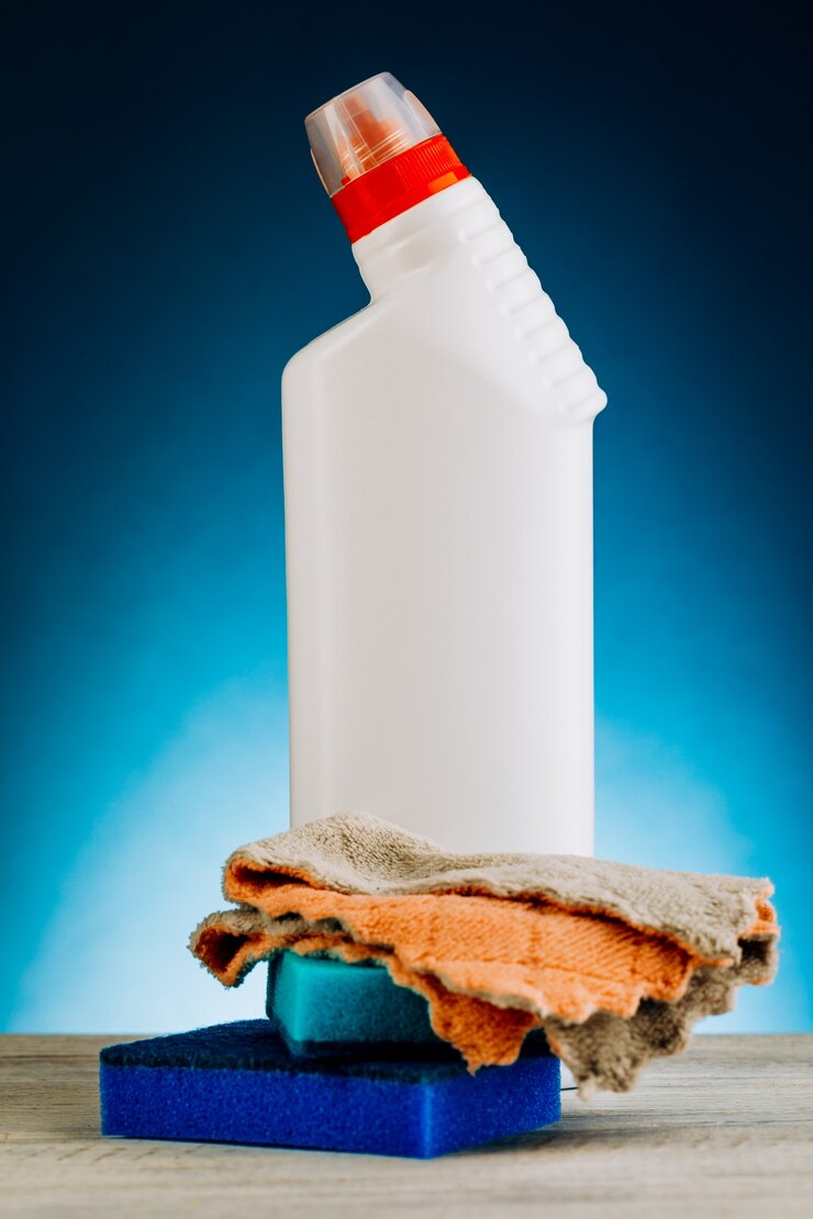 Foto várias garrafas de produtos de limpeza em um fundo azul.
