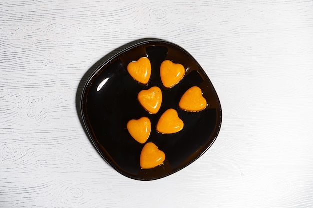 Varias gomitas en forma de corazón sobre una placa negra