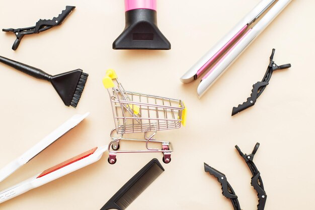 Varias herramientas de peluquería con carrito de compras en un concepto de salón de belleza de fondo beige