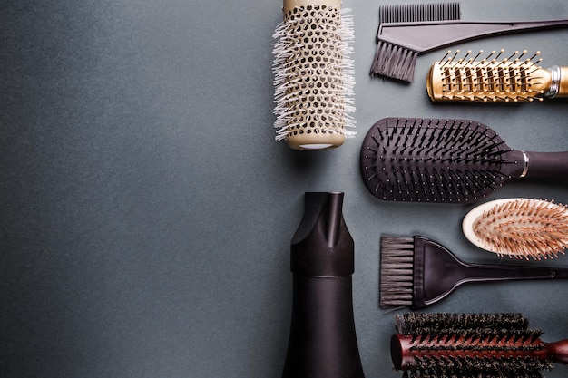 Varias herramientas de peluquería sobre fondo negro con espacio de copia