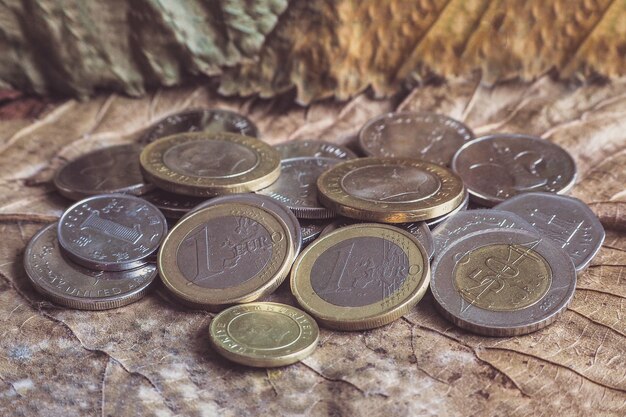 Varias monedas de dinero se apilan en una mesa vintage.