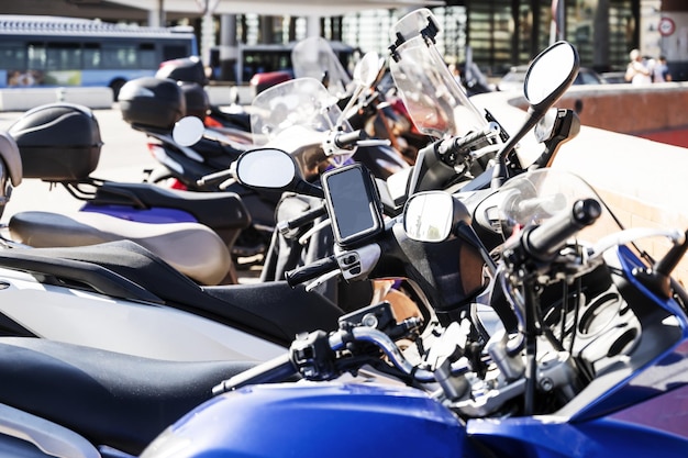 Foto varias motocicletas y ciclomotores de todo tipo estacionados en fila en una acera de una ciudad europea