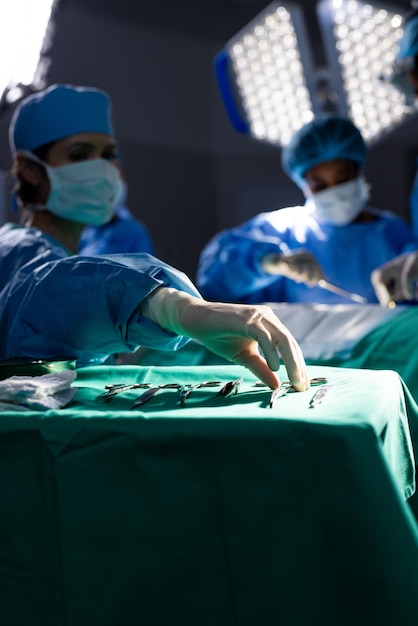 Foto varias mujeres médicas con máscaras faciales haciendo cirugía en la sala de operaciones del hospital