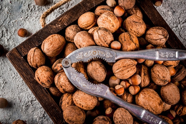 Varias nueces y cascanueces en caja de madera