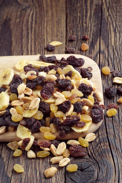 Varias nueces y pasas en la mesa de madera oscura.