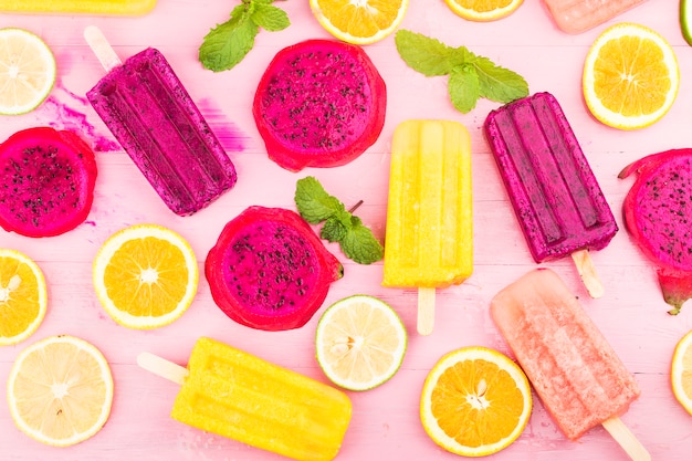 Varias paletas de fruta fresca colocadas sobre fondo de tablero de madera