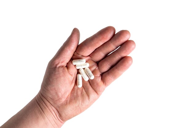Varias pastillas blancas en la mano aislar en blanco