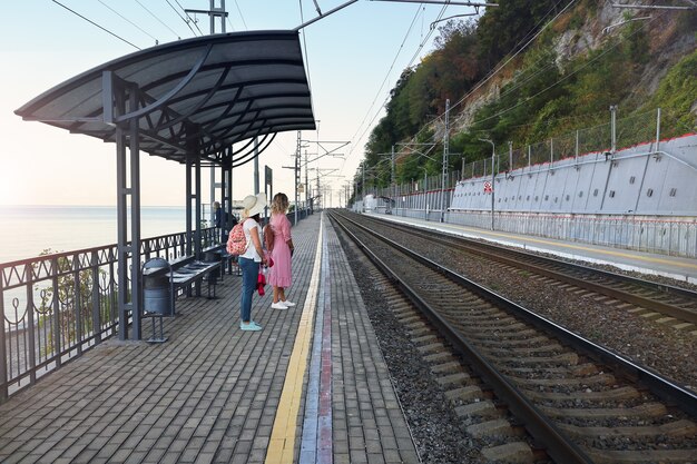 Varias personas esperan el tren de la mañana en el andén con poca gente