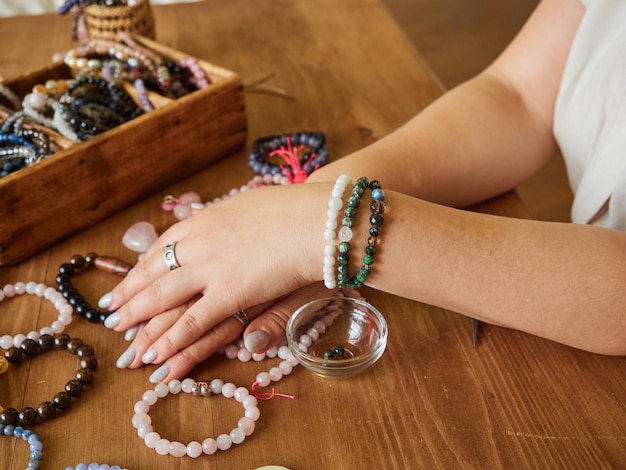 Varias pulseras elaboradas con piedras naturales en manos de una artesana. Concepto hecho a mano.