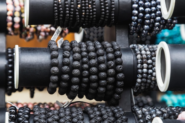 Varias pulseras de gemas hermosas negras apiladas juntas para la venta en el mercado