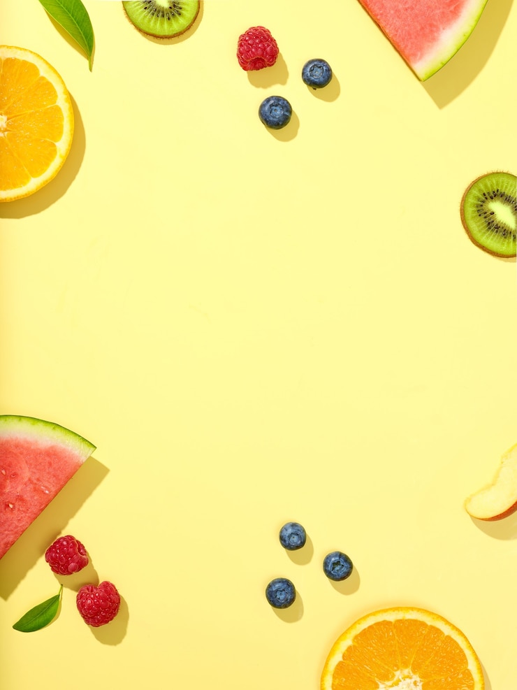 Foto varias rodajas de fruta fresca y bayas sobre fondo amarillo, vista superior