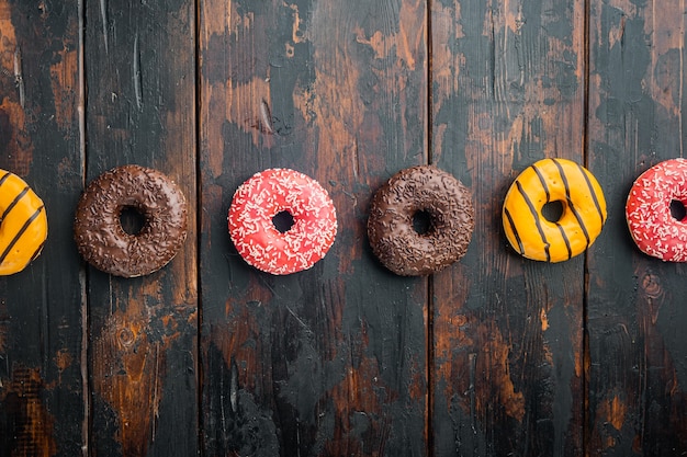 Varias rosquillas decoradas, sobre fondo antiguo de mesa de madera oscura, vista superior plana con espacio para copiar texto