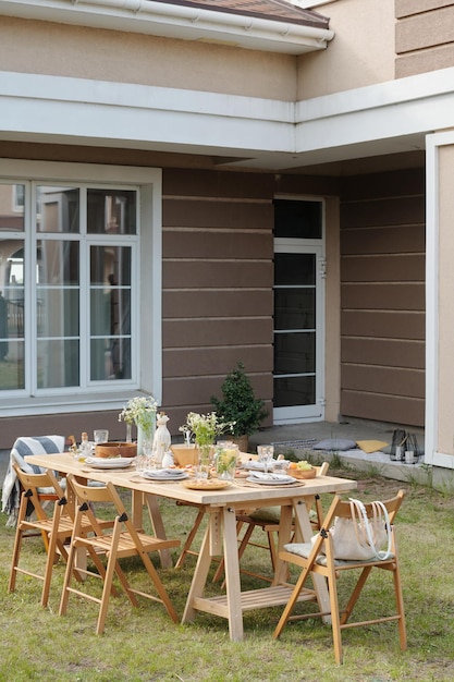 Varias sillas de madera que rodean la mesa servida con comida y bebidas caseras