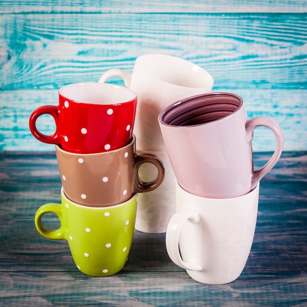 Foto varias tazas de té de colores sobre fondo azul vintage