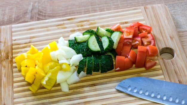 Varias verduras cortadas en madera. Pimiento morrón, cebolla, pepino y tomates. verduras