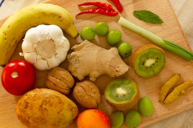 Varias verduras y frutas en la tabla de cortar