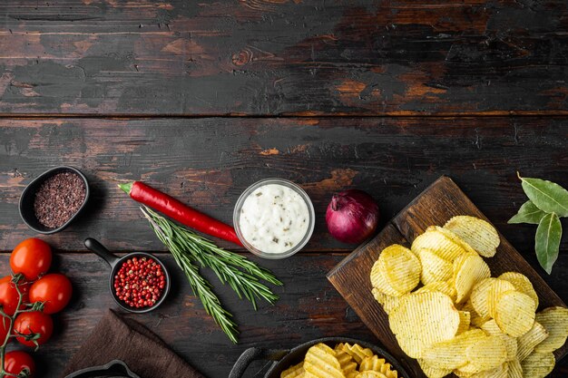 Variation verschiedene Kartoffelchips gesetzt, auf altem dunklem Holztisch, Draufsicht flach gelegt