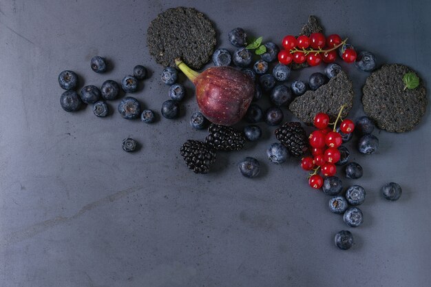 Variedad de bayas e higos con galletas negras.