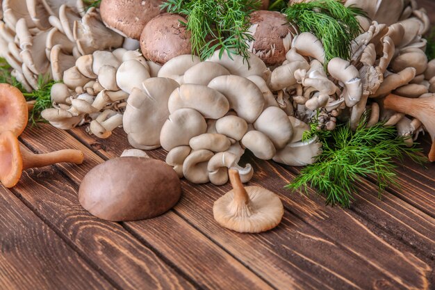 Variedad de champiñones crudos en mesa de madera