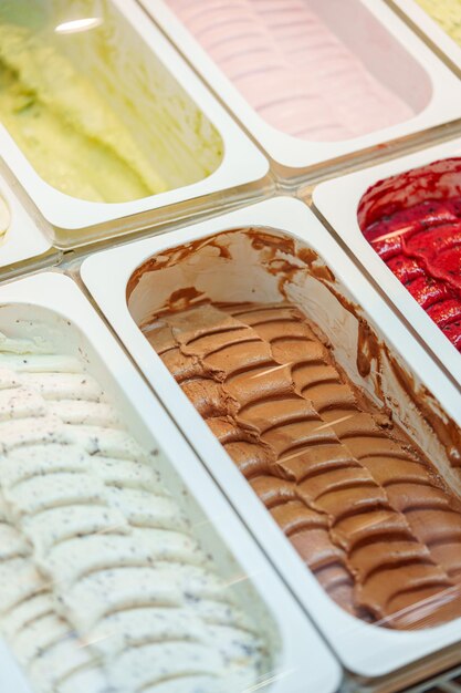 Una variedad colorida de sabores de gelato en una vitrina en una heladería italiana