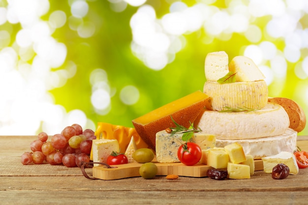 Variedad de composición de tipos de queso sobre tabla de madera.