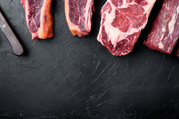 Variedad de filetes de carne de res cruda para asar a la parrilla con condimentos y utensilios de filete tomahawk t bone club