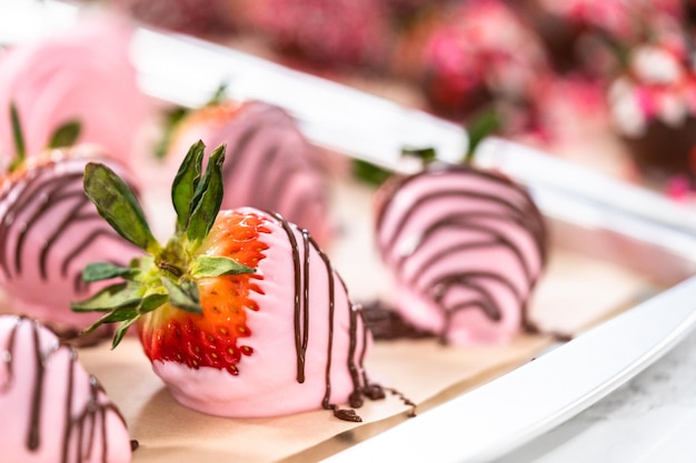 Variedad de fresas bañadas en chocolate sobre papel pergamino.