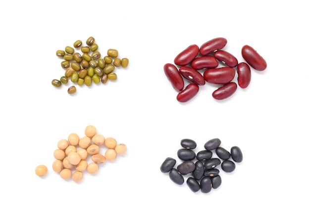 Una variedad de frijoles en superficie blanca