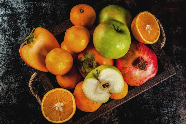 Variedad de fruta fresca en bandeja de madera.