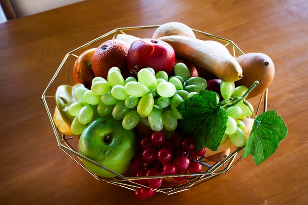 Variedad de frutas en una cesta de aluminio sobre una mesa de madera en el comedor del restaurante cafetería cafetería para tailandeses y viajeros servicio de uso al cliente en Nakhon Pathom Tailandia