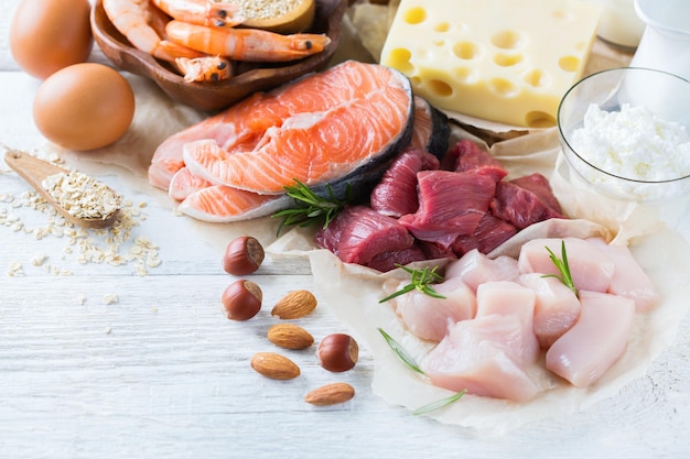 Variedad de fuentes de proteínas saludables y alimentos para el desarrollo del cuerpo Carne de res salmón camarones huevos de gallina productos lácteos leche queso yogur frijoles quinoa nueces avena