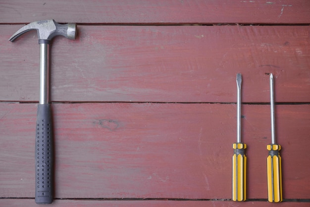 variedad de herramientas manuales bien utilizadas extendidas sobre una superficie de madera desgastada indicativa de un espacio de trabajo o un banco de trabajo