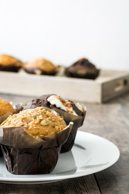 Variedad de muffins en una mesa de madera.