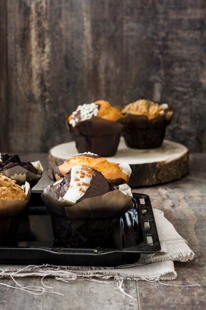 Variedad de muffins en una mesa de madera.