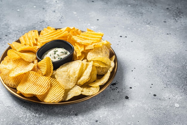 Variedad de papas fritas en un plato servido con salsa dip Fondo gris Vista superior Espacio de copia