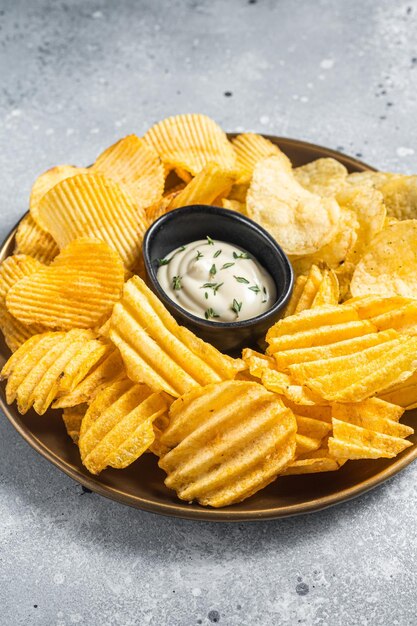 Variedad de papas fritas en un plato servido con salsa dip Fondo gris Vista superior