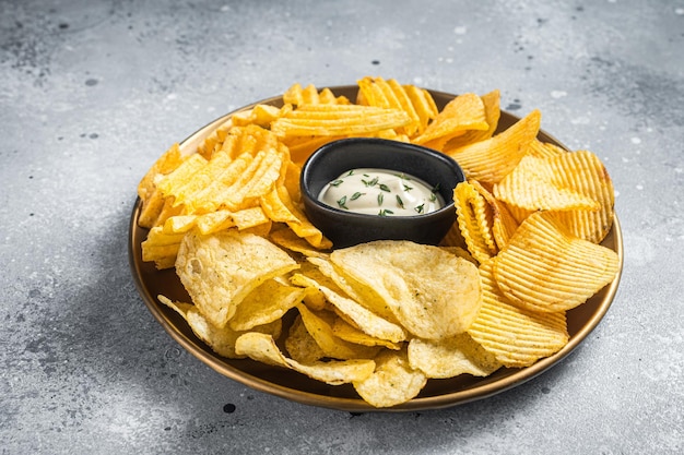 Variedad de papas fritas en un plato servido con salsa dip Fondo gris Vista superior