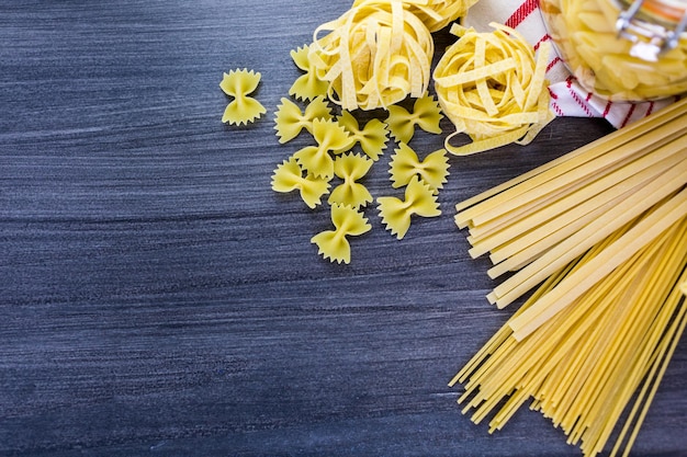 Variedad de pasta seca orgánica sobre tablero de madera.